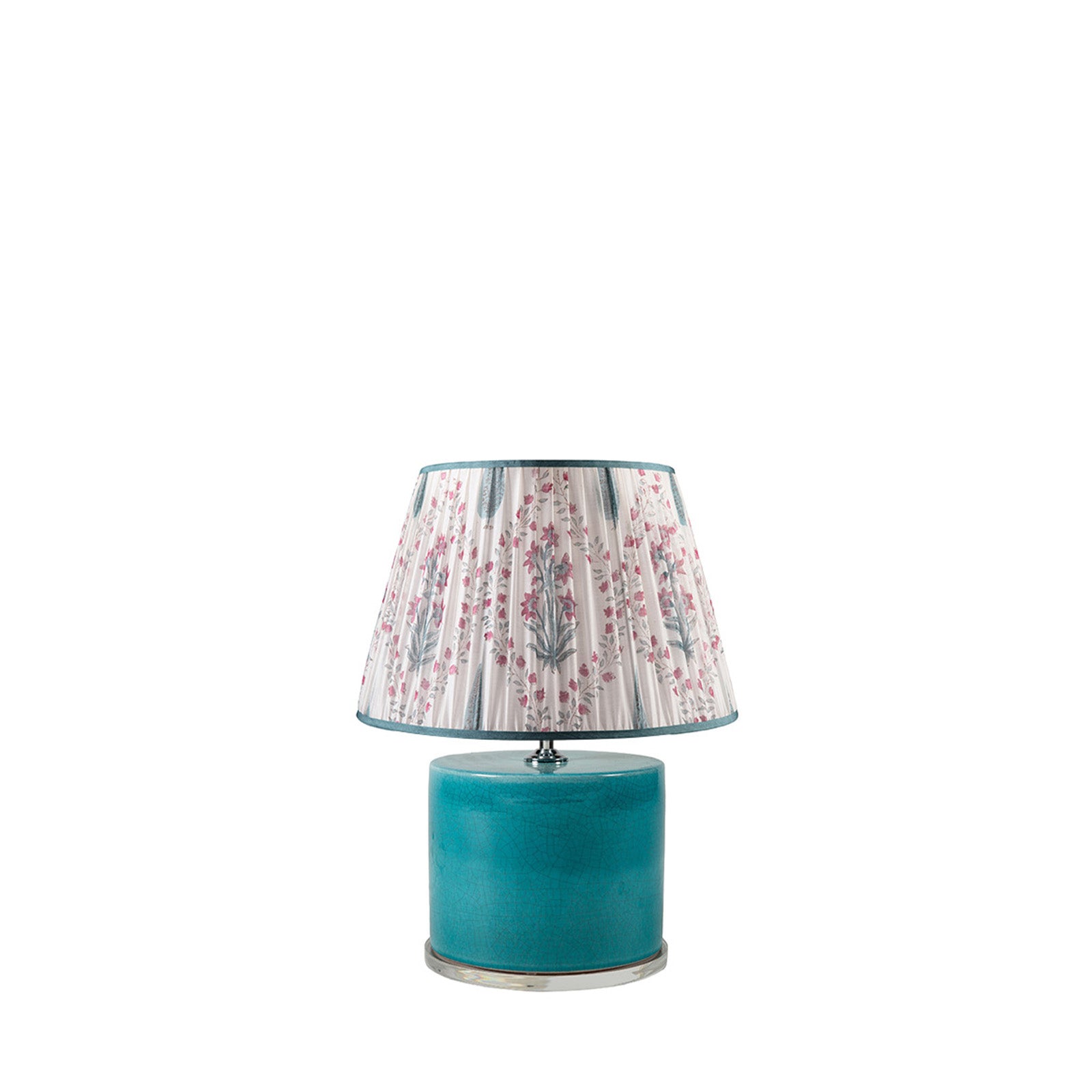Teal table lamp with a floral-patterned shade on a white background