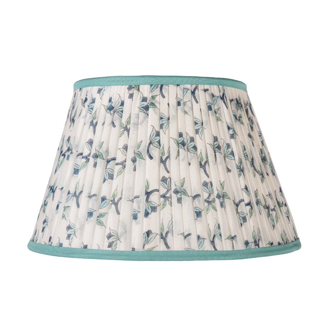 Lampshade with floral pattern and teal trim on a white background