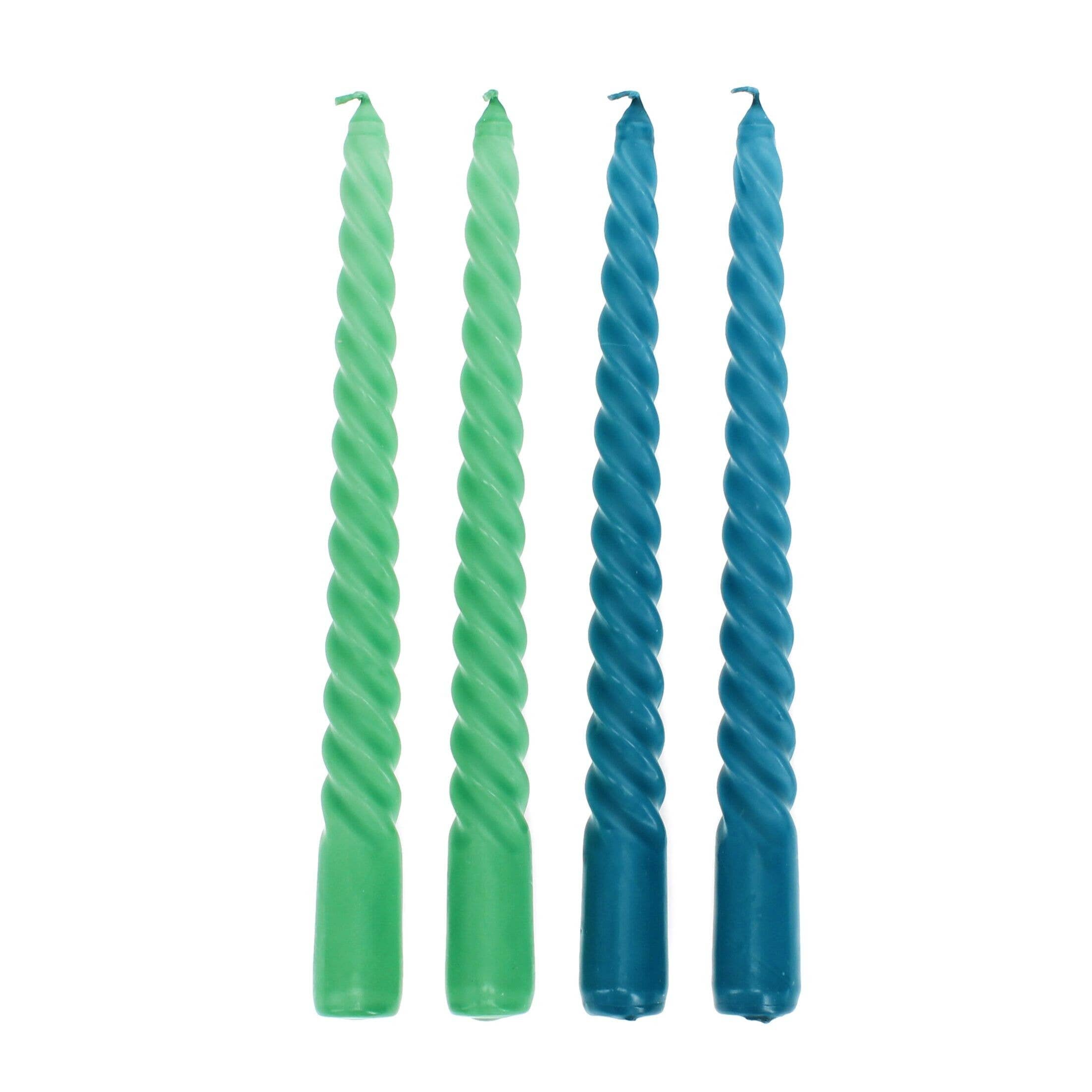 Two pairs of green and blue twisted candles on a white background