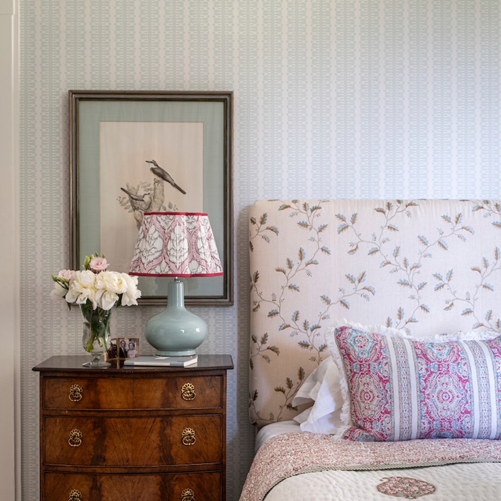 Bedroom with floral headboard and nightstand, Ivy lamp in sky blue, and hearts and minds blue wallpaper