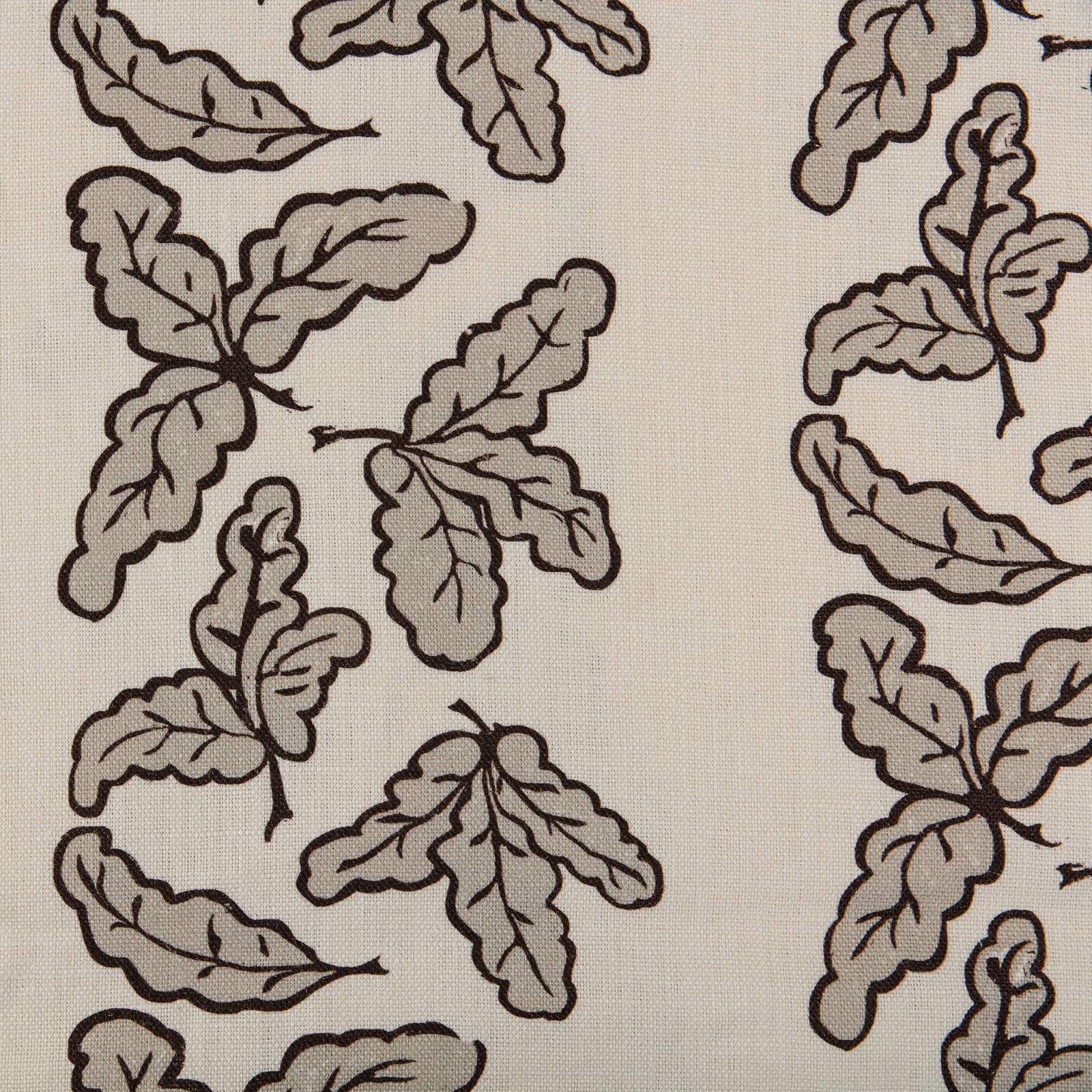 A fabric featuring an oak leaf pattern in a putty color, on a white background.